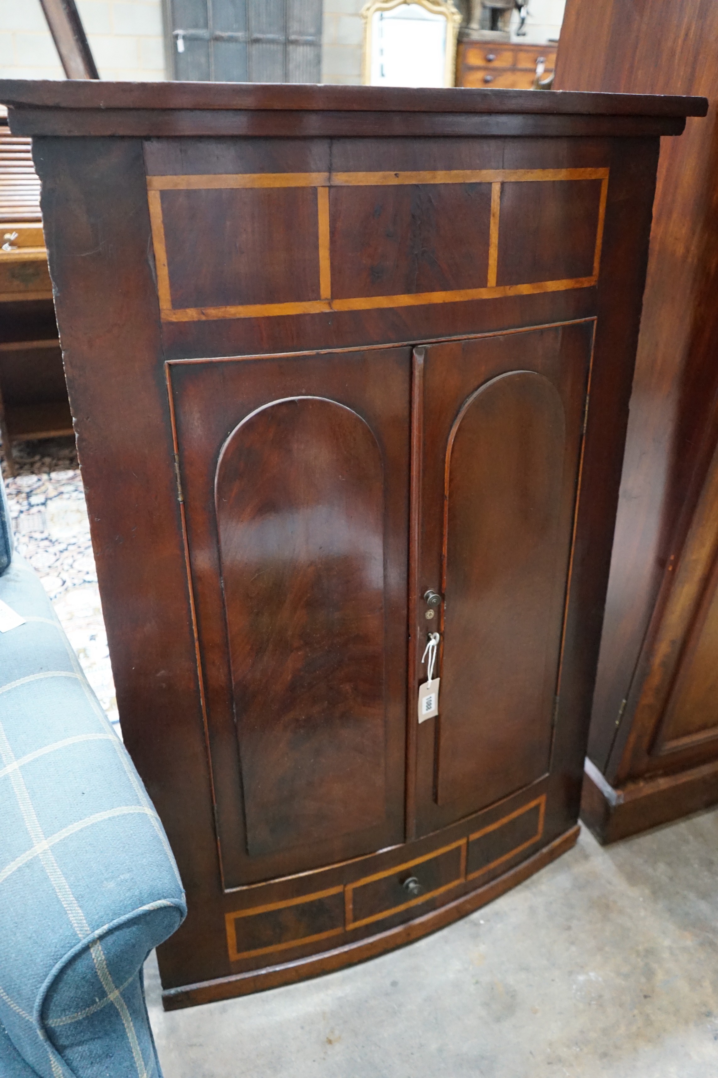 A George III banded mahogany bow front hanging corner cabinet, width 86cm, height 126cm